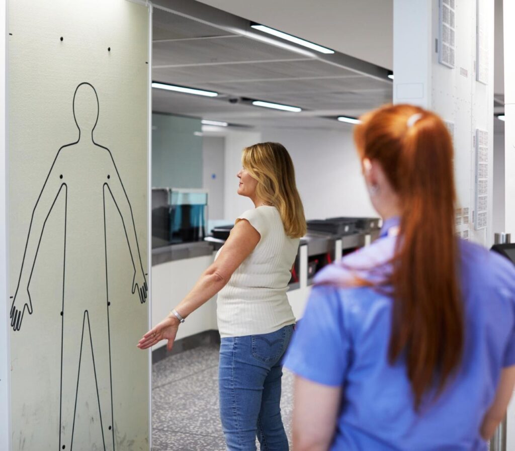 A female passenger at airport security being screened using c3 screening technology